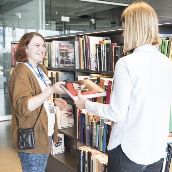 Bibliotekar anbefaler bog til borger.