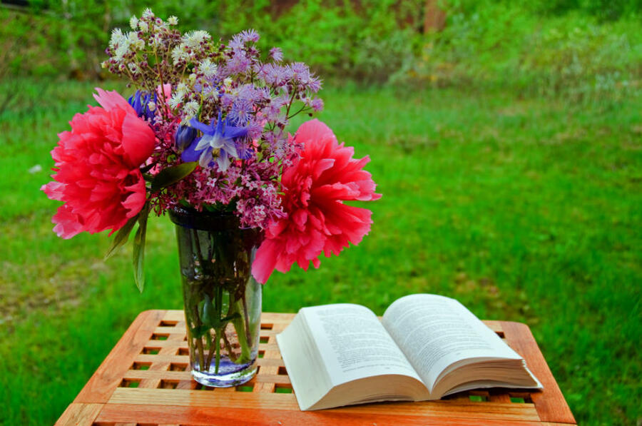 Et bord med en bog og en buket blomster